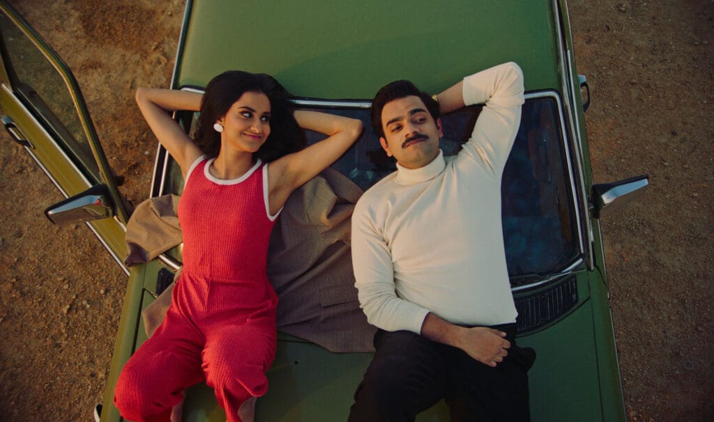 Amrit Kaur as Young Mariam; Hamza Haq as Hassan lay on hood of car in 'The Queen of My Dreams'