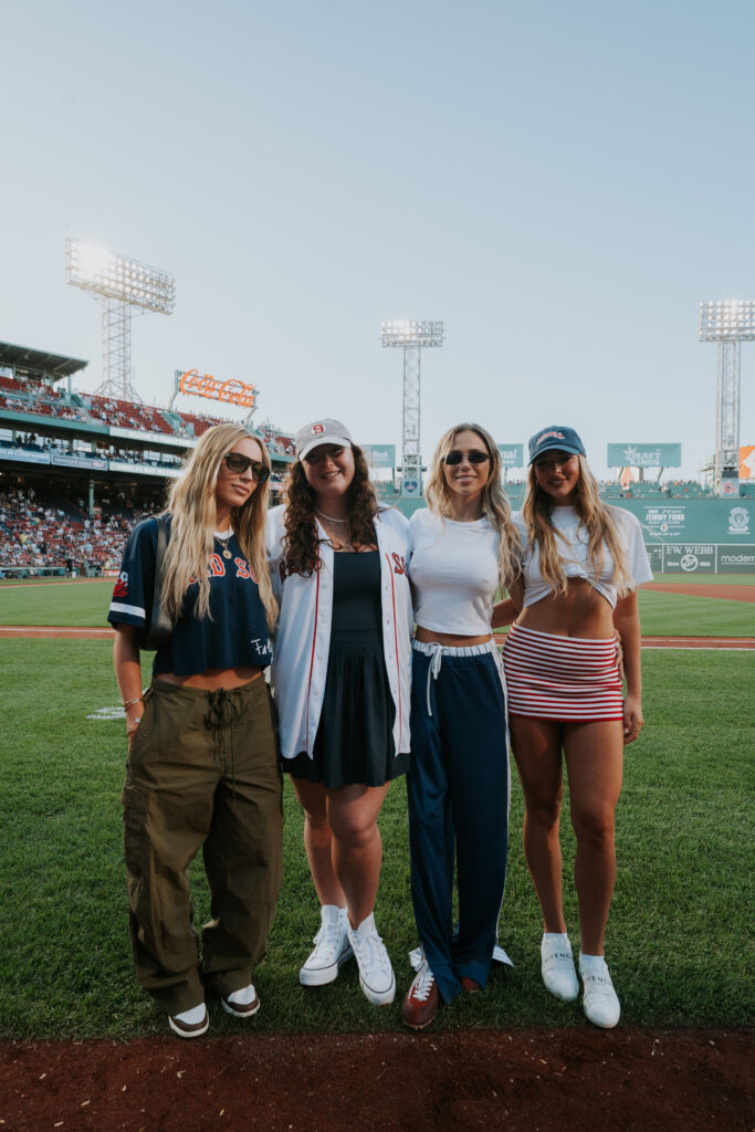 Alex Cooper, Grace O'Malley, Hallie Batchelder, and Kendall Vertes pose on the field at Fenway Park