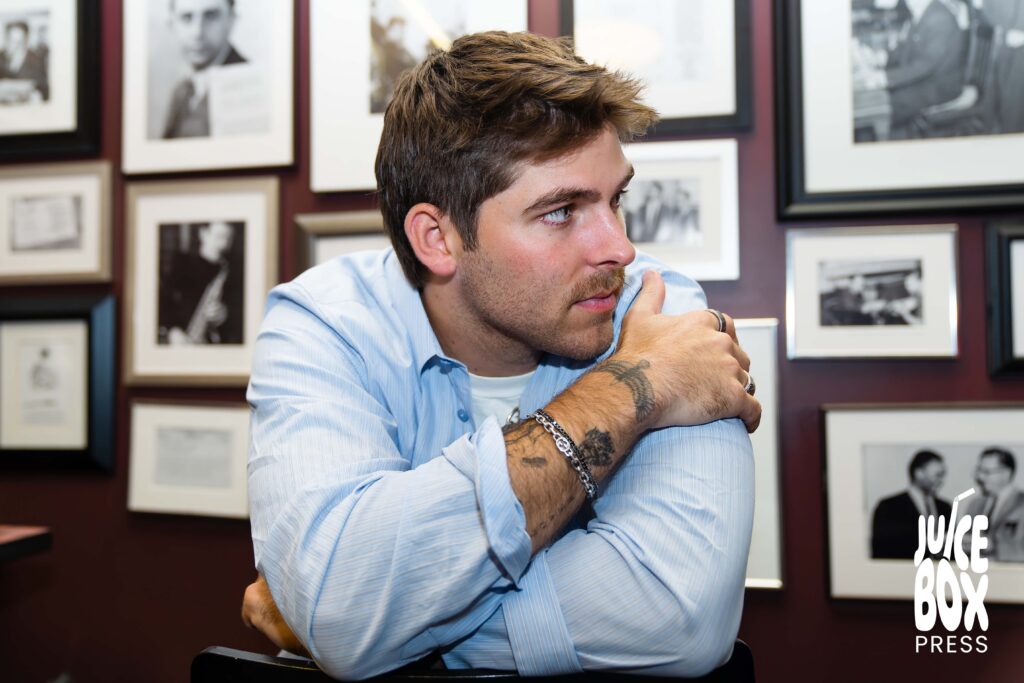 GUNNAR posing in front of a photo collage wall