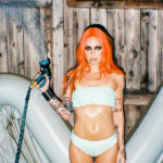 press photo of Bea Miller in front of an inflatable pool holding a hose